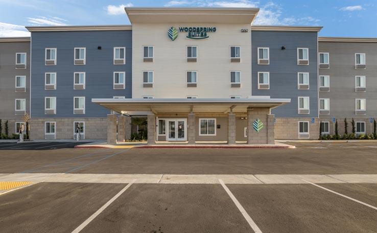 Exterior view of the WoodSpring suites hotel in Bellflower, CA.