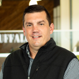 Chris Smith smiling and standing in buffalo's office space.