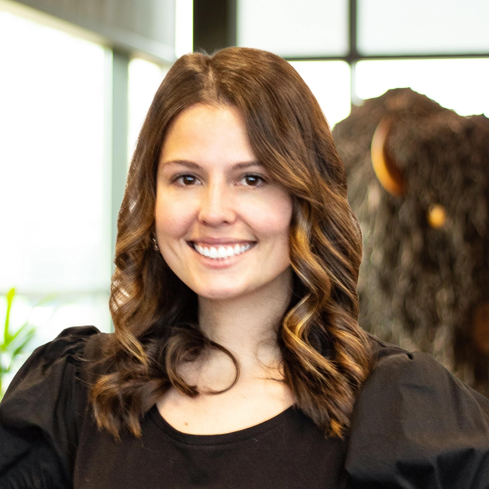 Lee Fowler smiling as she stands in front of a statue of a buffalo.