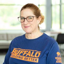Rachel Steele wearing a buffalo branded shirt and smiling in a bright, modern office.