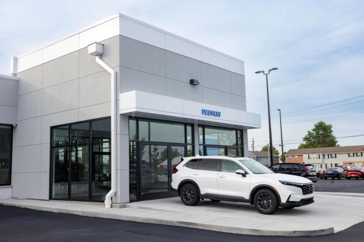 Completed Honda vehicle delivery area with a modern gray-and-white exterior, glass entrance and covered delivery bay.