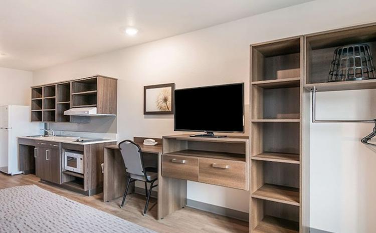 Guest bedroom with TV in the WoodSpring Suites hotel in Missoula, MT.
