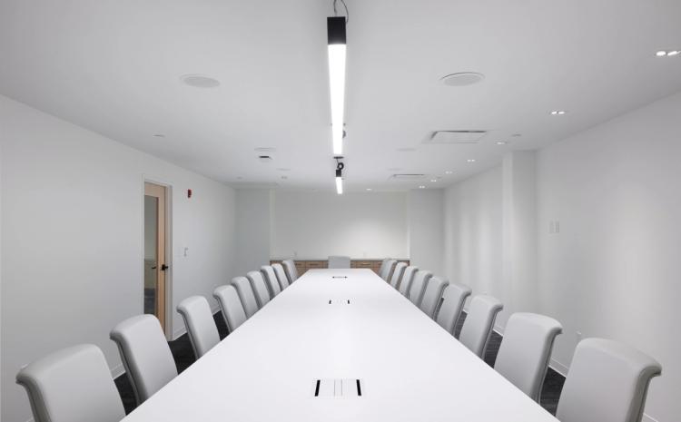 Conference room with long white table.
