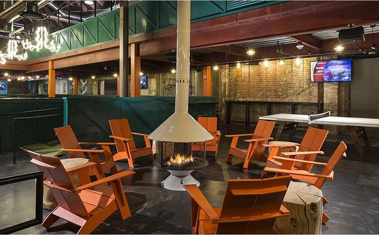Lawn chair seating around indoor fire pit at Punch Bowl Social.