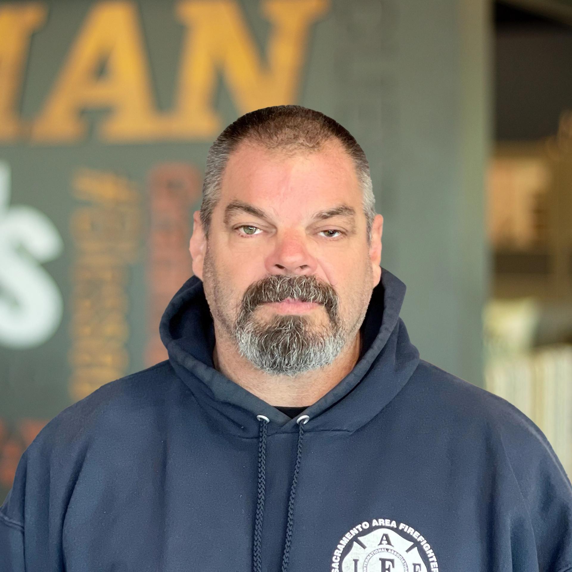Donnie Gossett standing in front of a company-branded wall.