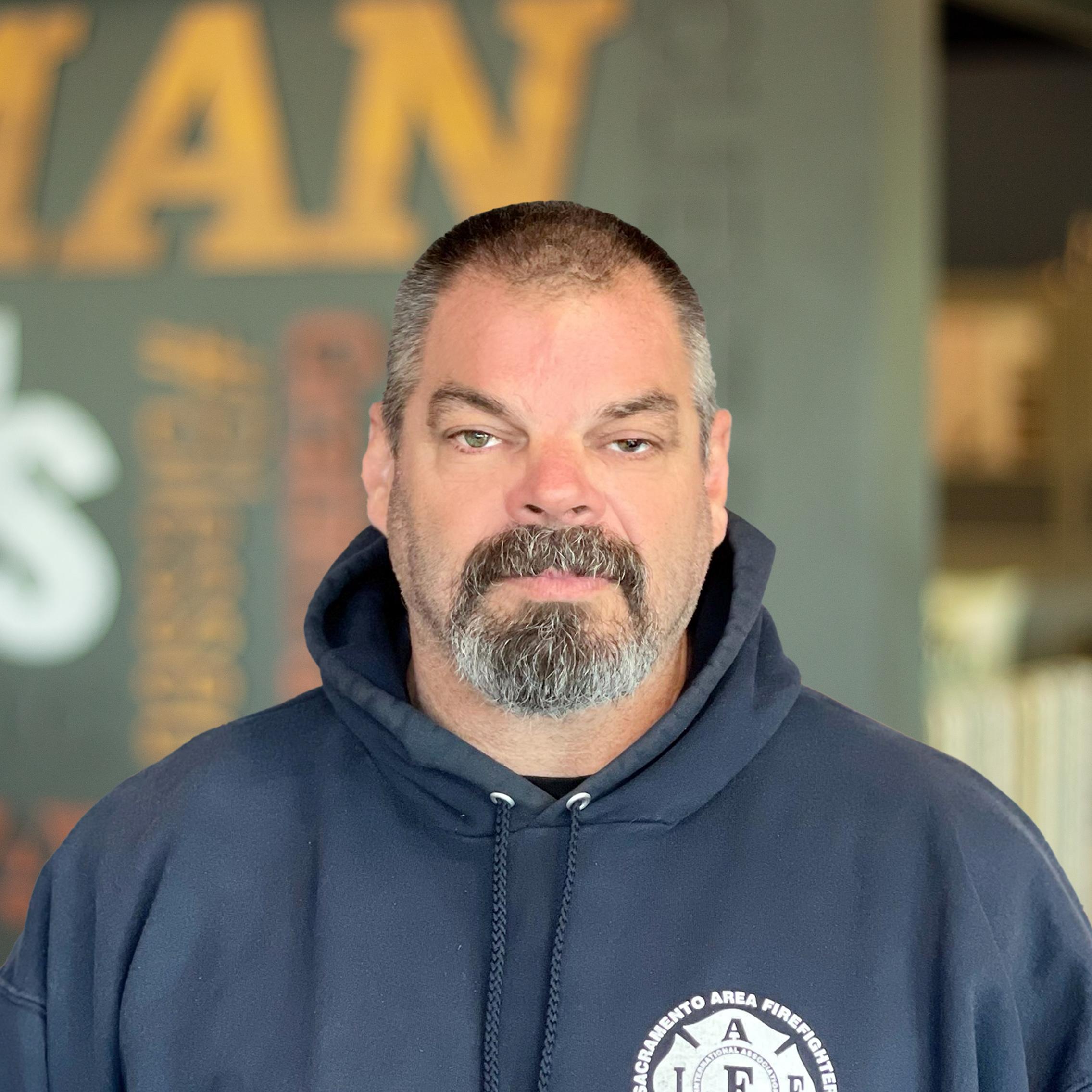 Donnie Gossett standing in front of a company-branded wall.