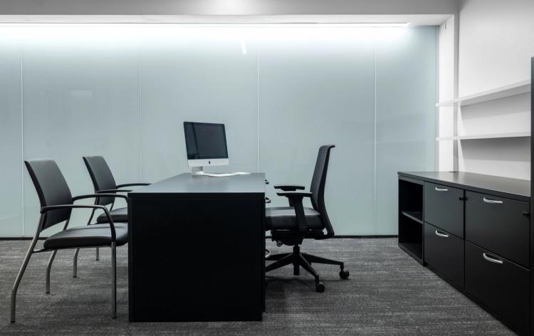 Private office with black desk and chairs.