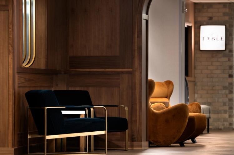 Velvet and leather lounge seating near "TABLE" sign