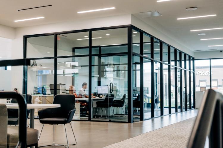 Completed Neil Huffman Honda interior with glass-enclosed offices, customer seating and a bright, open showroom design.