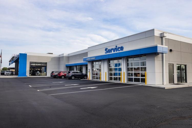 Completed Neil Huffman Honda service entrance featuring three overhead service doors, blue signage and updated exterior finishes.