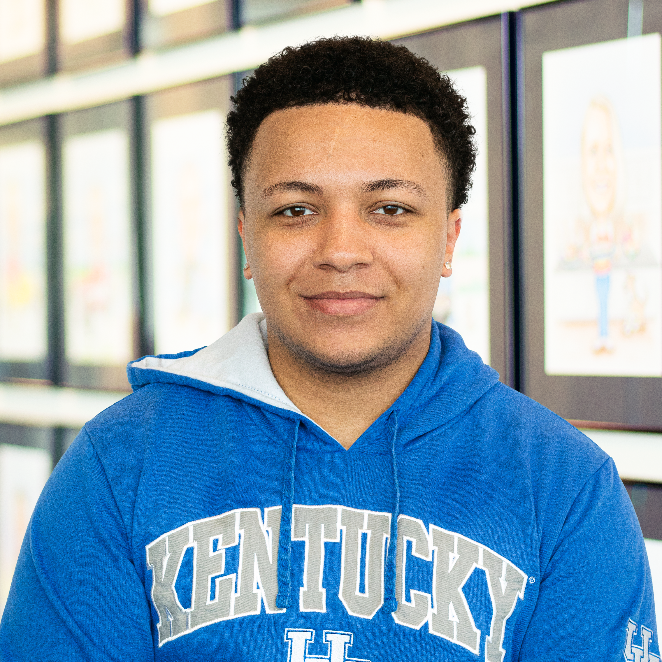 Cameron Faulkner standing in front of a wall displaying framed caricatures.