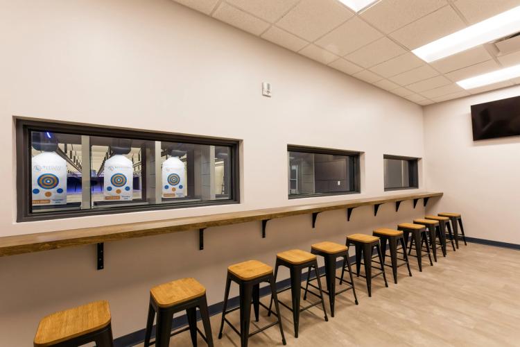 Viewing area overlooking indoor shooting range lanes.