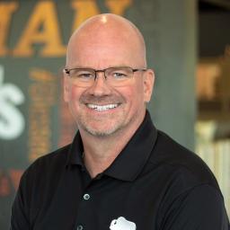 Curtis Rowan wearing a black Buffalo Construction polo and standing in front of a company-branded wall.