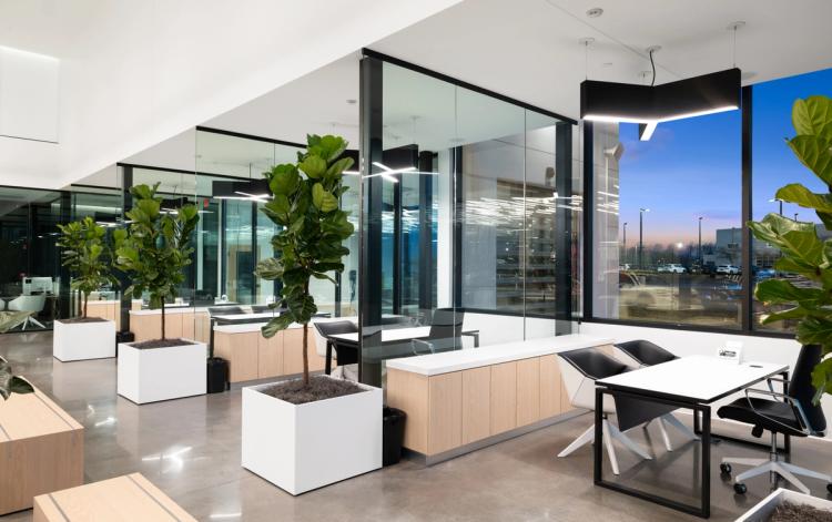Wide showroom with vehicles and lounge.