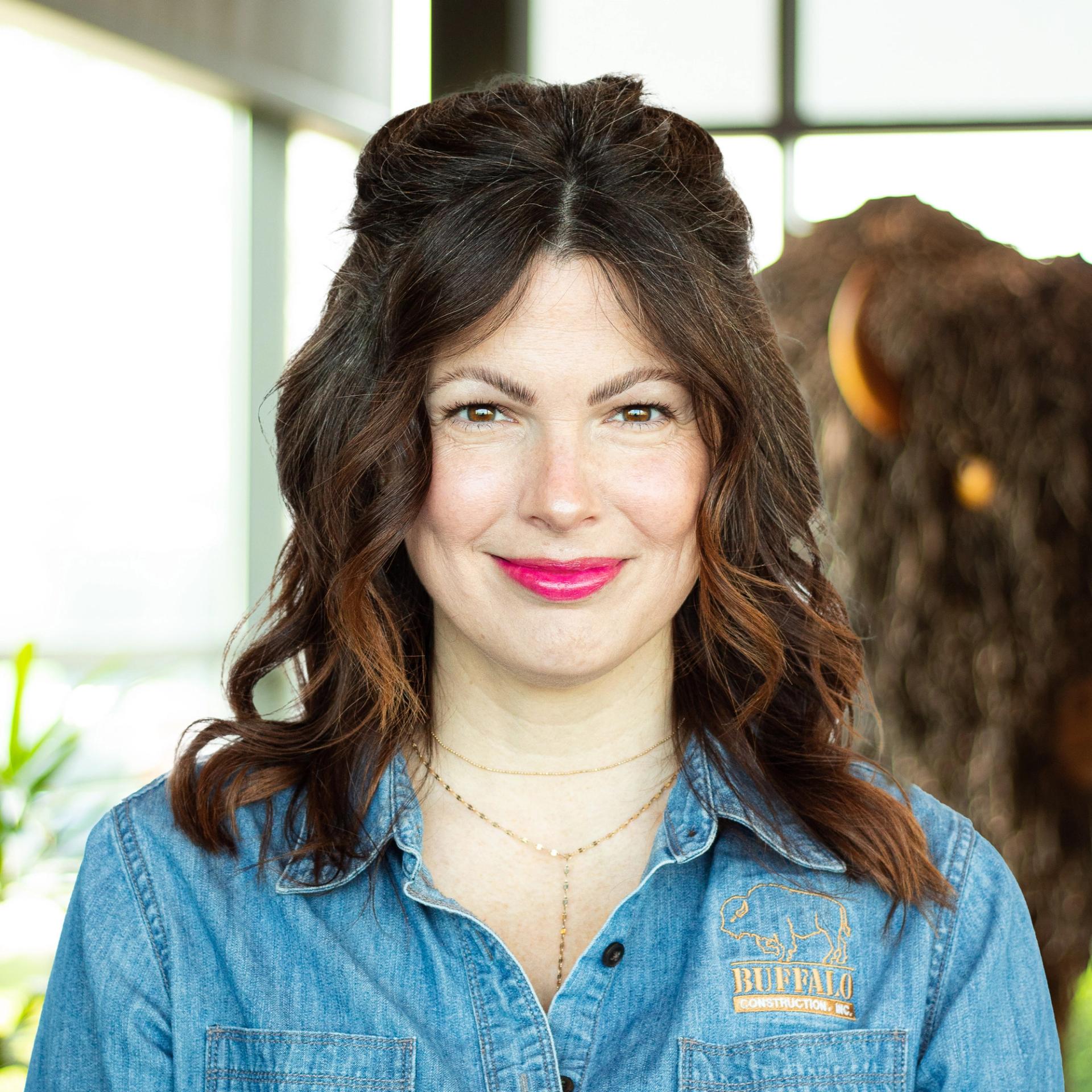 Lauren Aberli wearing a large smile, standing in buffalo's office space.