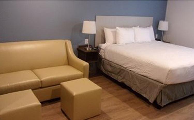 Guest bedroom and couch at the WoodSpring Suites hotel in Norco, CA.