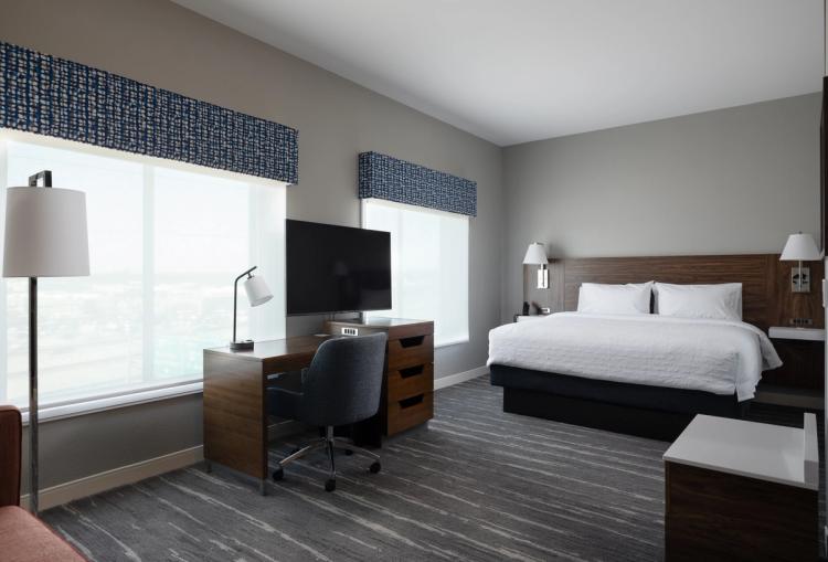 Guest room view of desk and king bed in Hampton Inn and Suites in Louisville, KY.