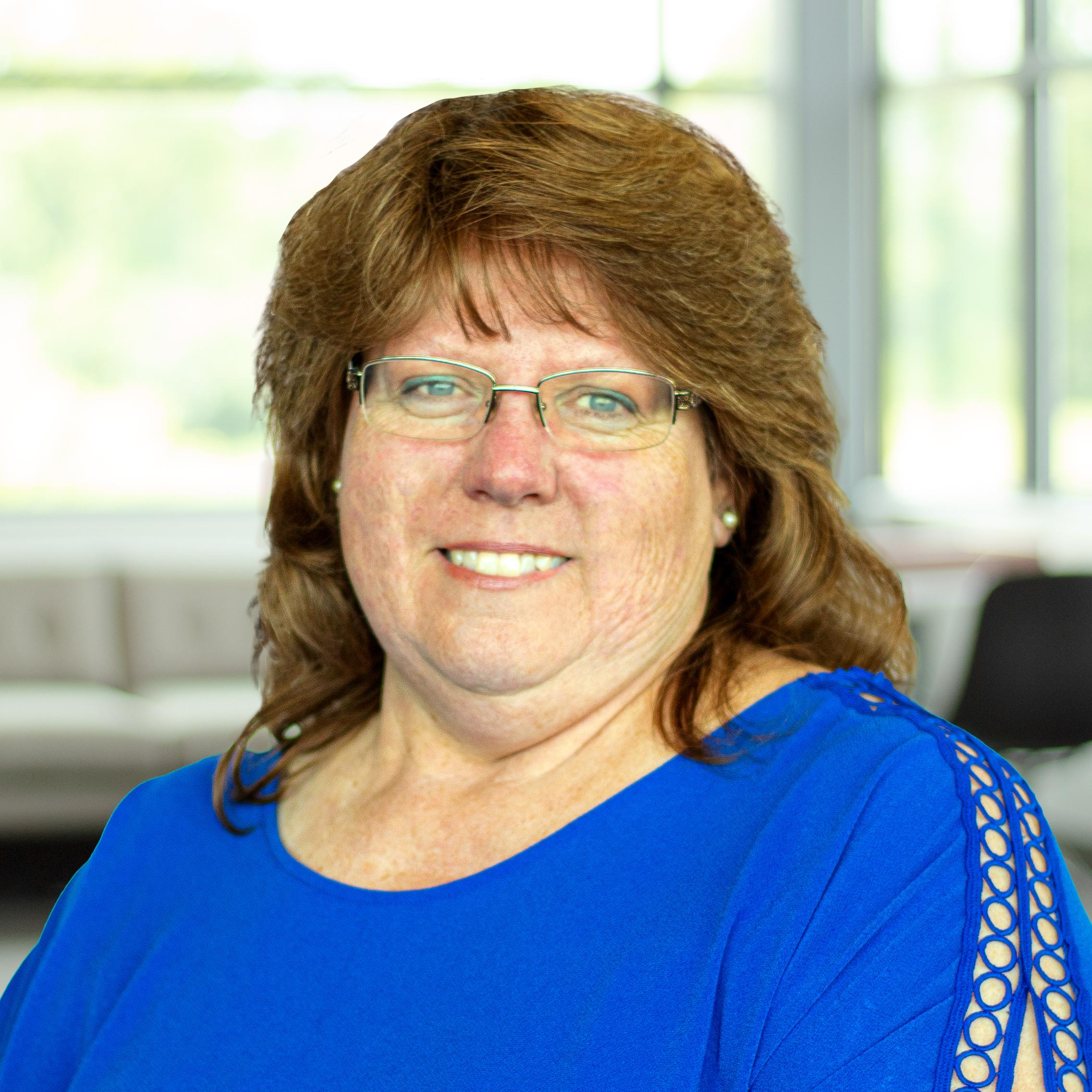 Laura Marlin smiling in a bright, modern office.