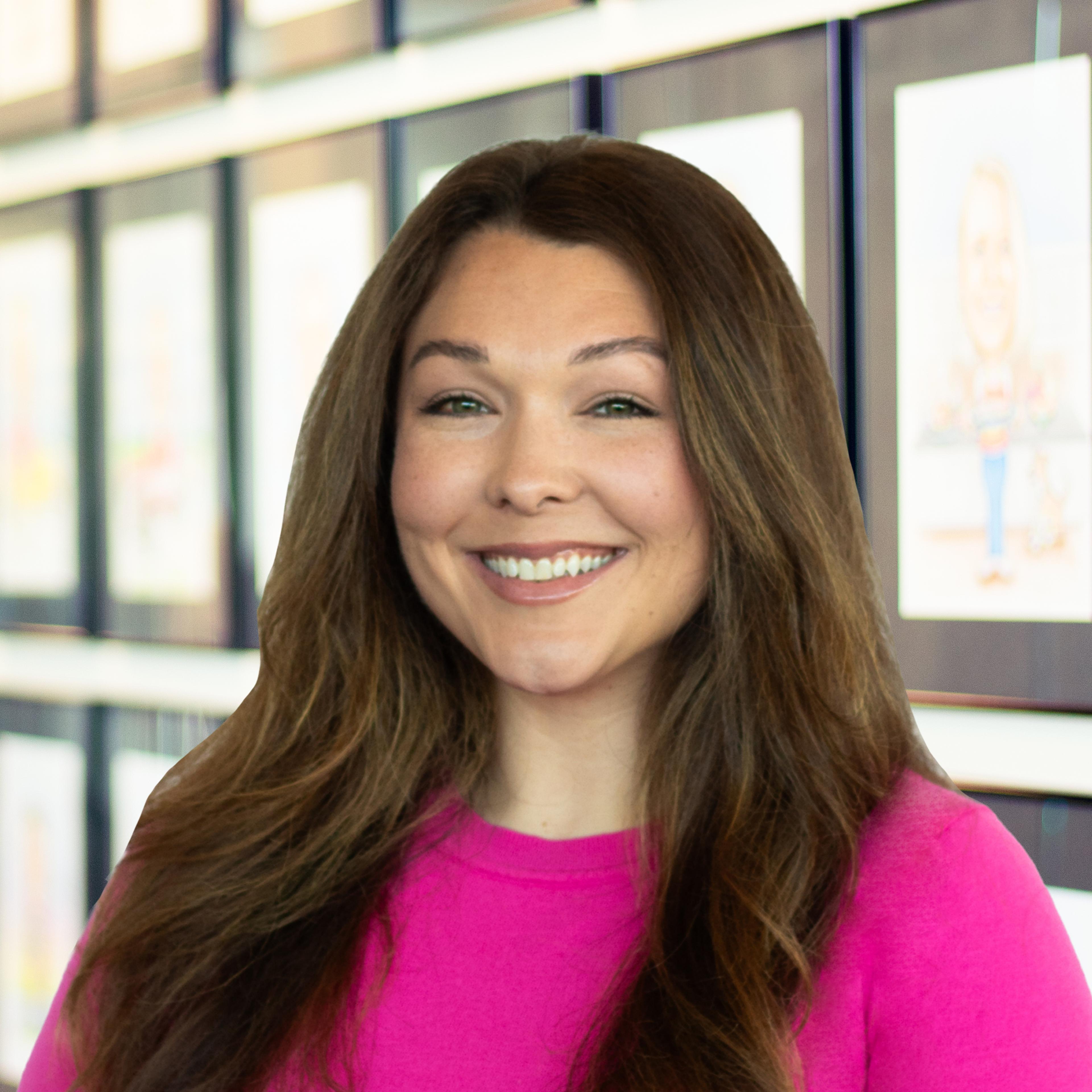 Olivia Tobbe wearing a gray Buffalo Construction polo shirt, smiling in a bright, modern office.
