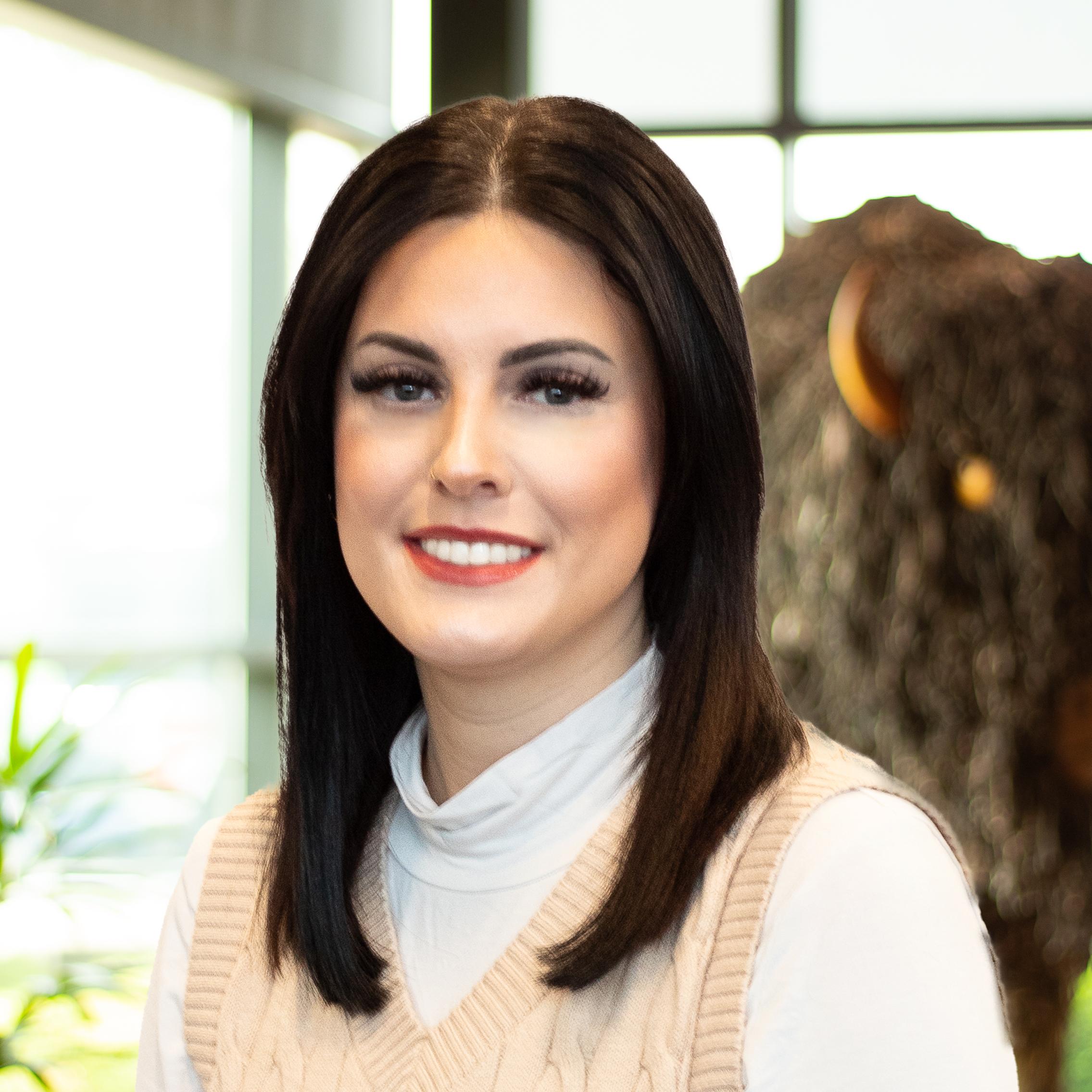 LeeAnn Diaz smiling as she stands in front of a statue of a buffalo.
