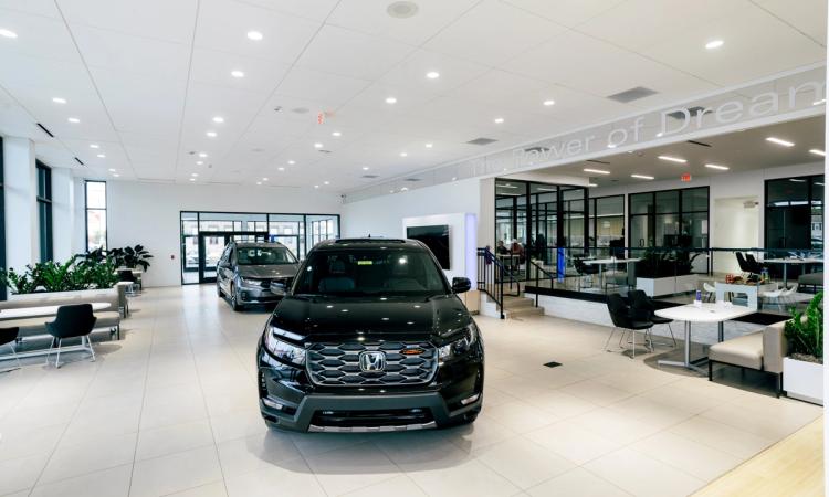 Completed Neil Huffman Honda showroom featuring vehicle displays, customer seating, glass offices and a bright open floor plan.