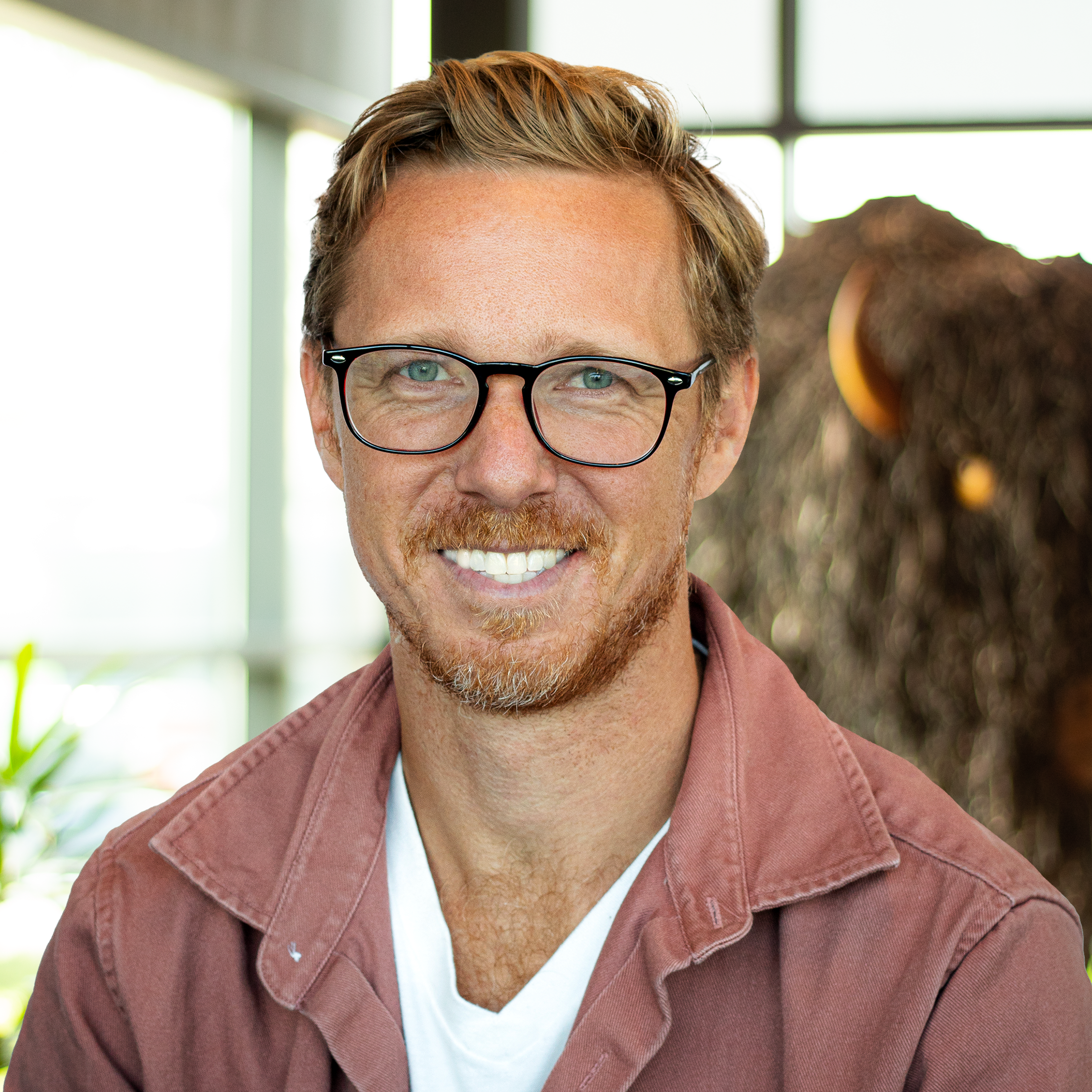 Cory Zilisch smiling brightly as he stands in front of a statue of a buffalo.