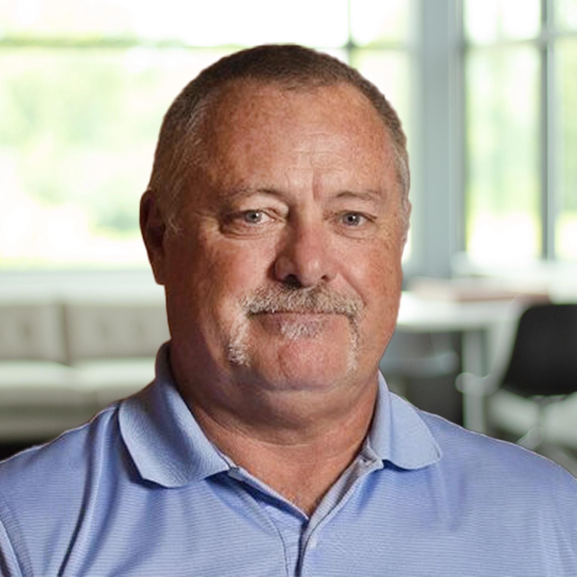 Craig Abraham smiling in a bright, modern office.