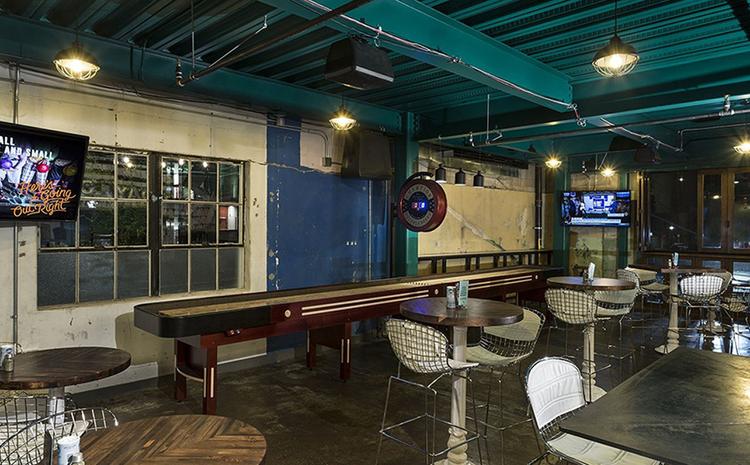 Shuffleboard table and tabletop seating at Punch Bowl Social.