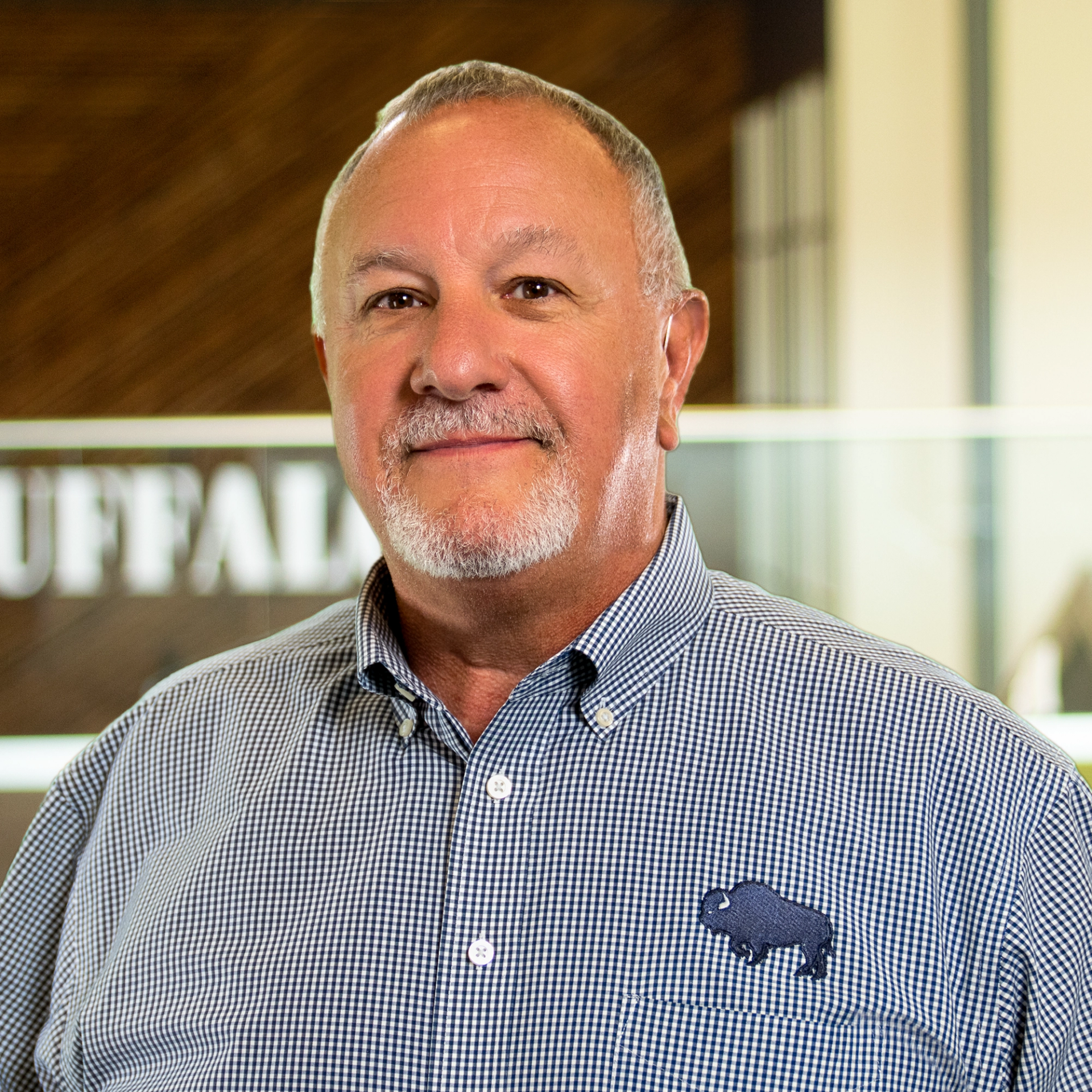 John Hunter wearing a button down, looking distinguished in a bright, modern office.