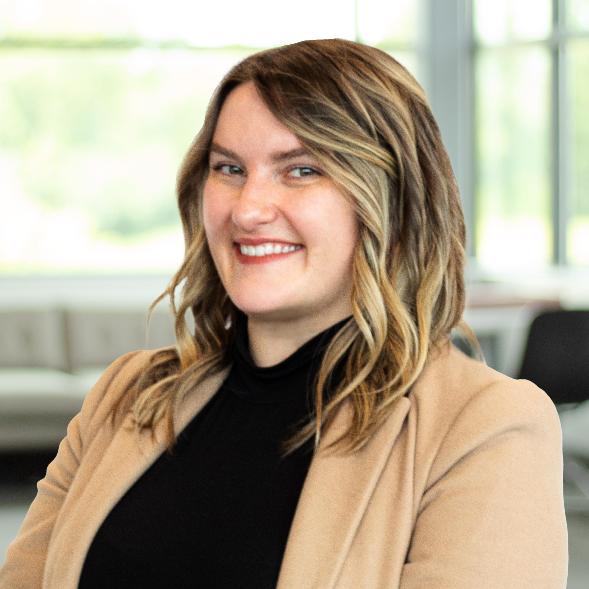 Megan Jones wearing a smile in a bright, modern office.