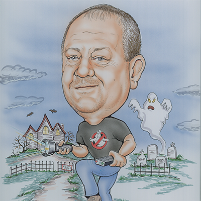 Caricature of David Greenwell hunting ghost, wearing a ghostbusters t-shirt while he holds a flashlight and is followed by a ghost in a cemetery next to a haunted house.