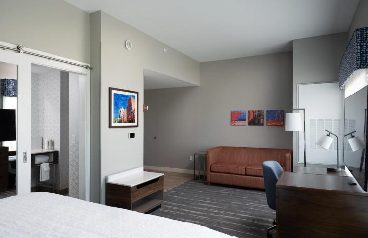 Guest room view of desk and sofa in Hampton Inn and Suites in Louisville, KY.