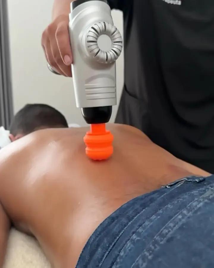 Fisioterapeuta aplicando vibropercusión en la espalda de un paciente en Vitalita, Barranquilla