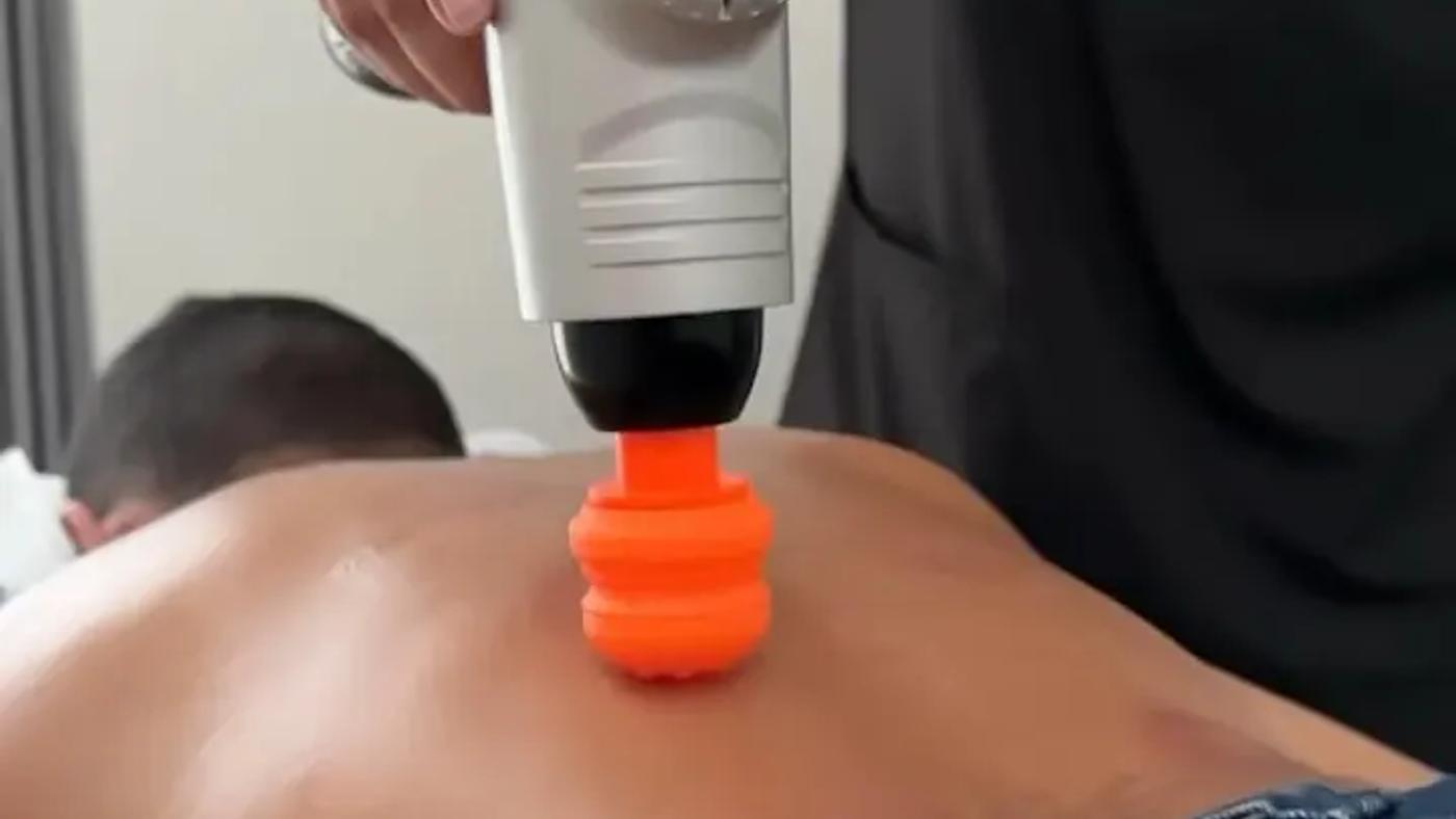Fisioterapeuta aplicando vibropercusión en la espalda de un paciente en Vitalita, Barranquilla