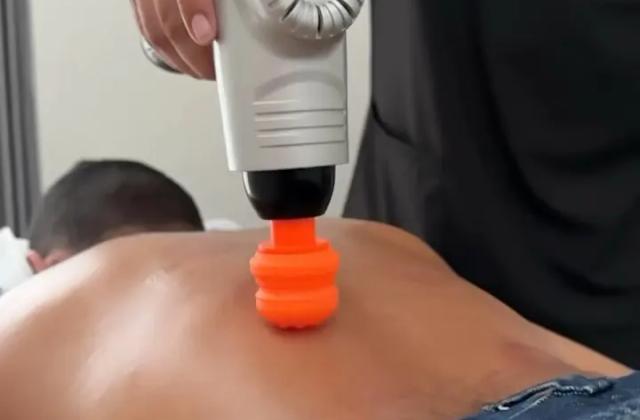 Fisioterapeuta aplicando vibropercusión en la espalda de un paciente en Vitalita, Barranquilla