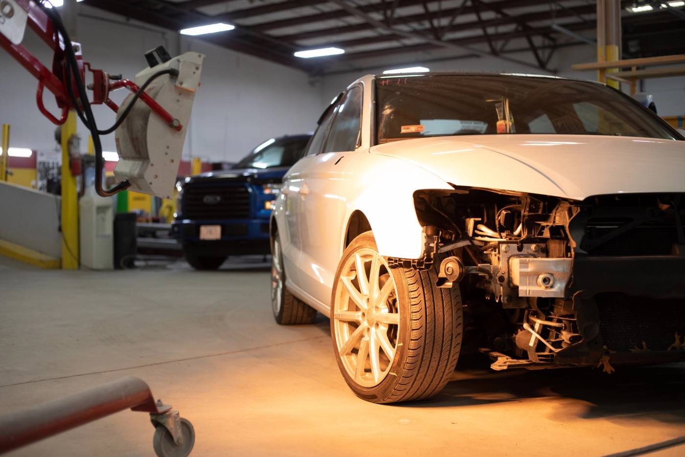A silver Audi with its front end disassembled for collision repair