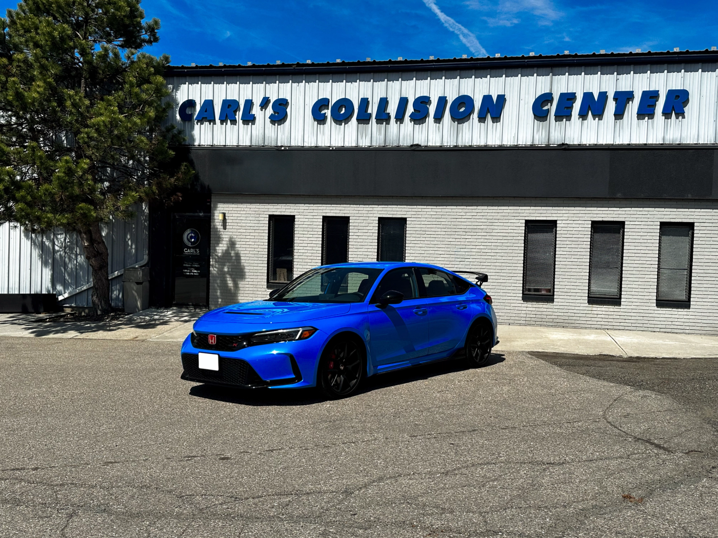 A Honda Civic in front of the Carl's Collision Fall River storefront