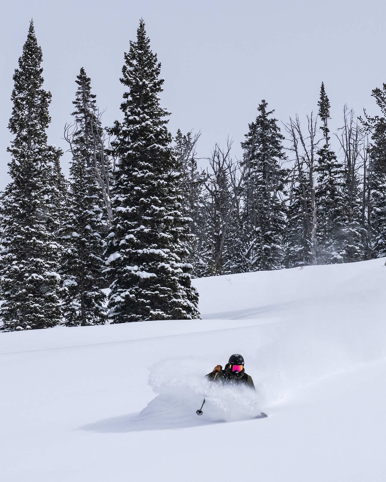 A skier riding through waist deep snow.