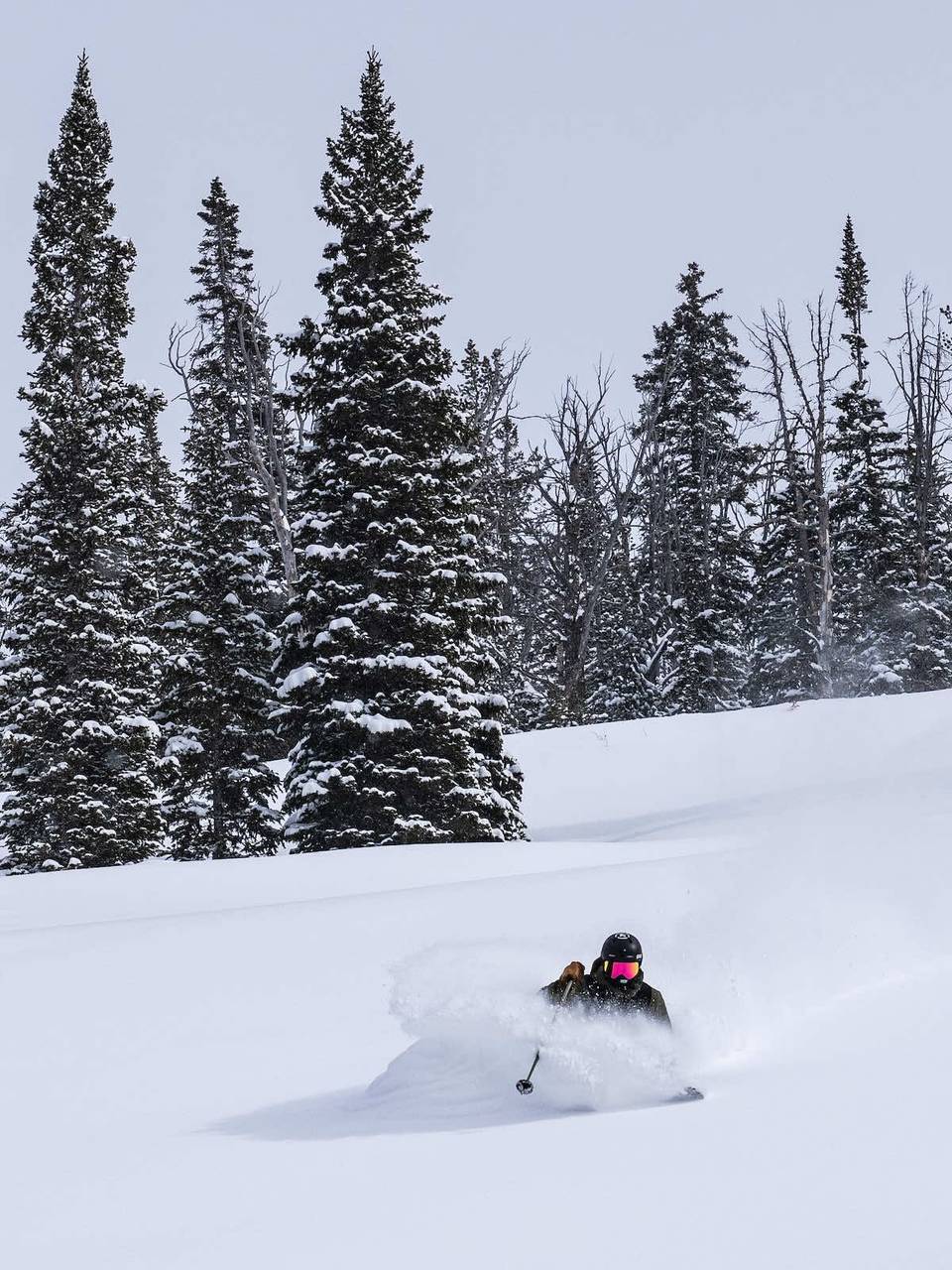 A skier riding through waist deep snow.