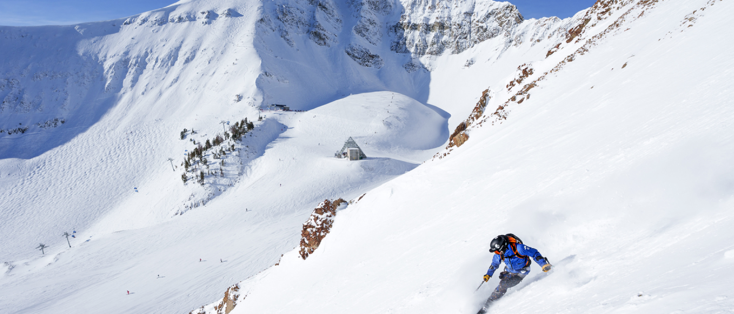 A skier going downhill near the former Lone Peak Tram building