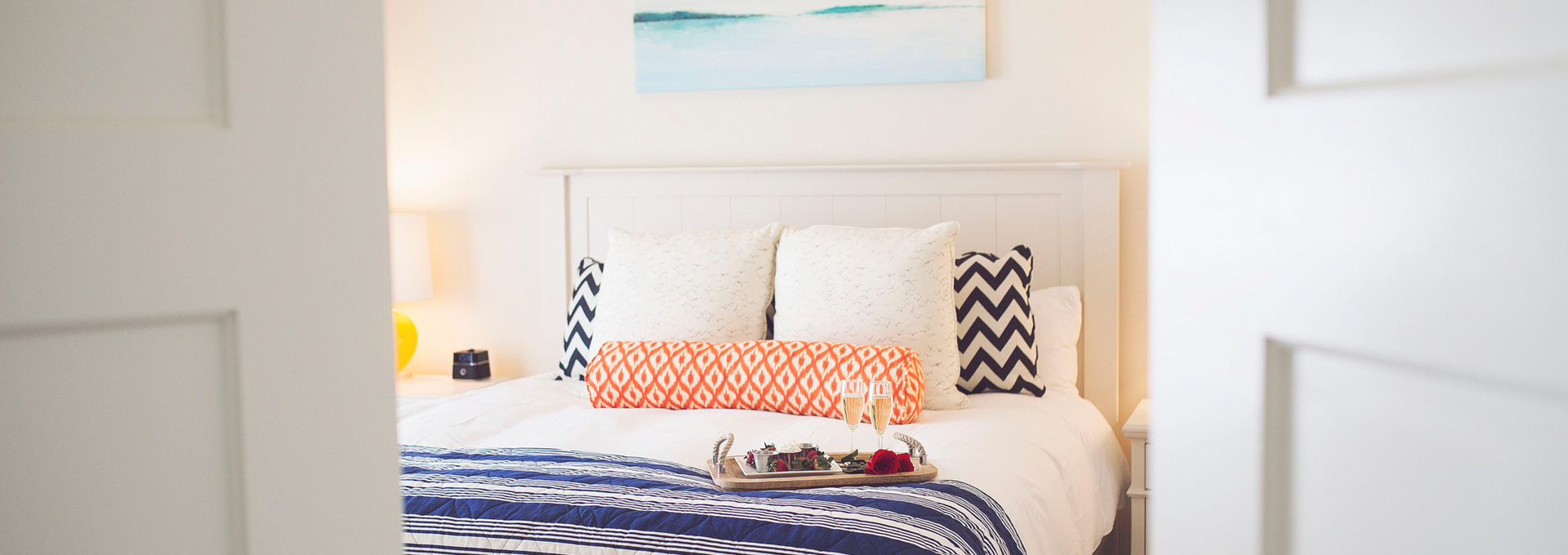 View of hotel bed through double doors.