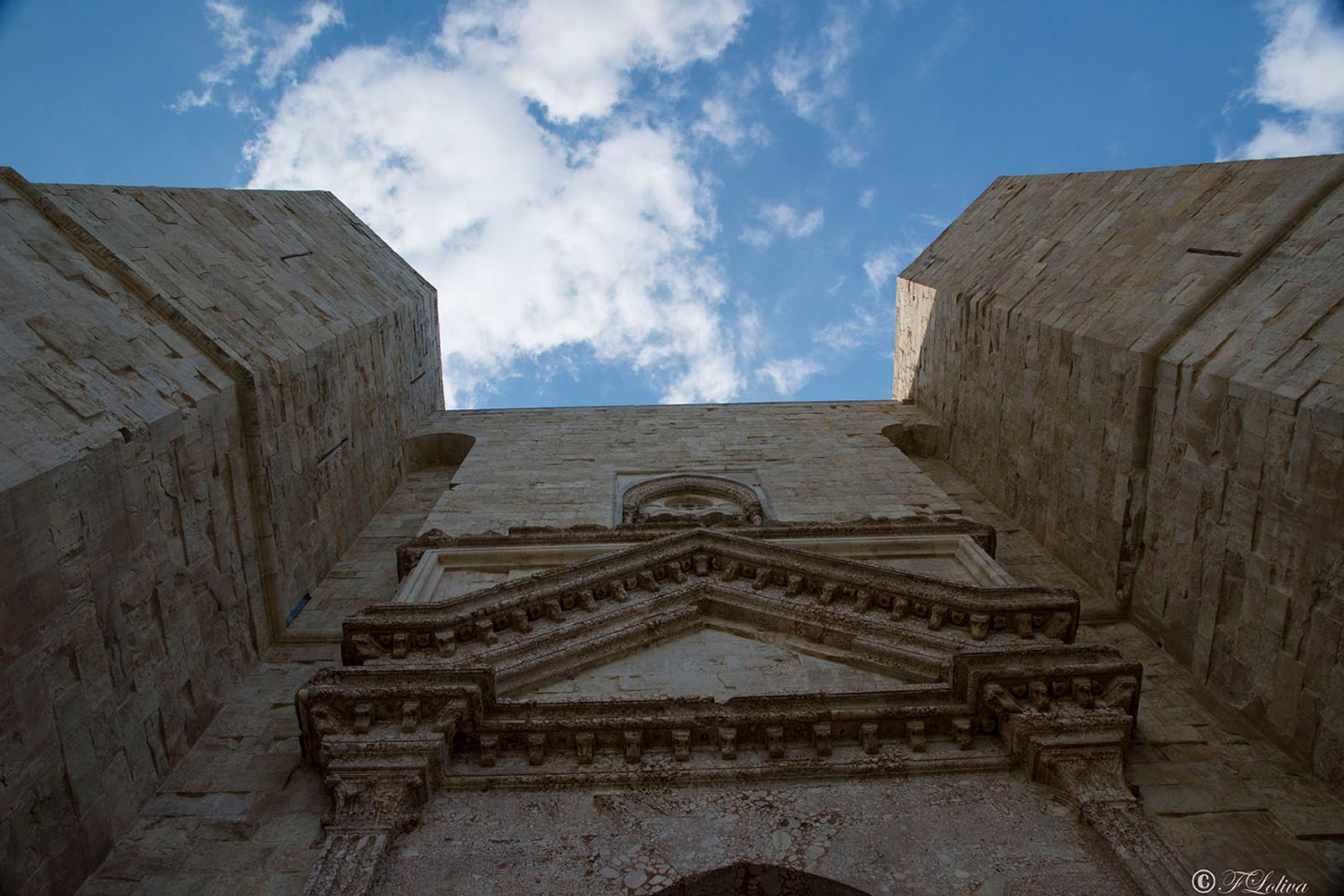 L'ingresso principale, in breccia corallina, riproduce la forma di un arco trionfale classico che incornicia un arco a…
