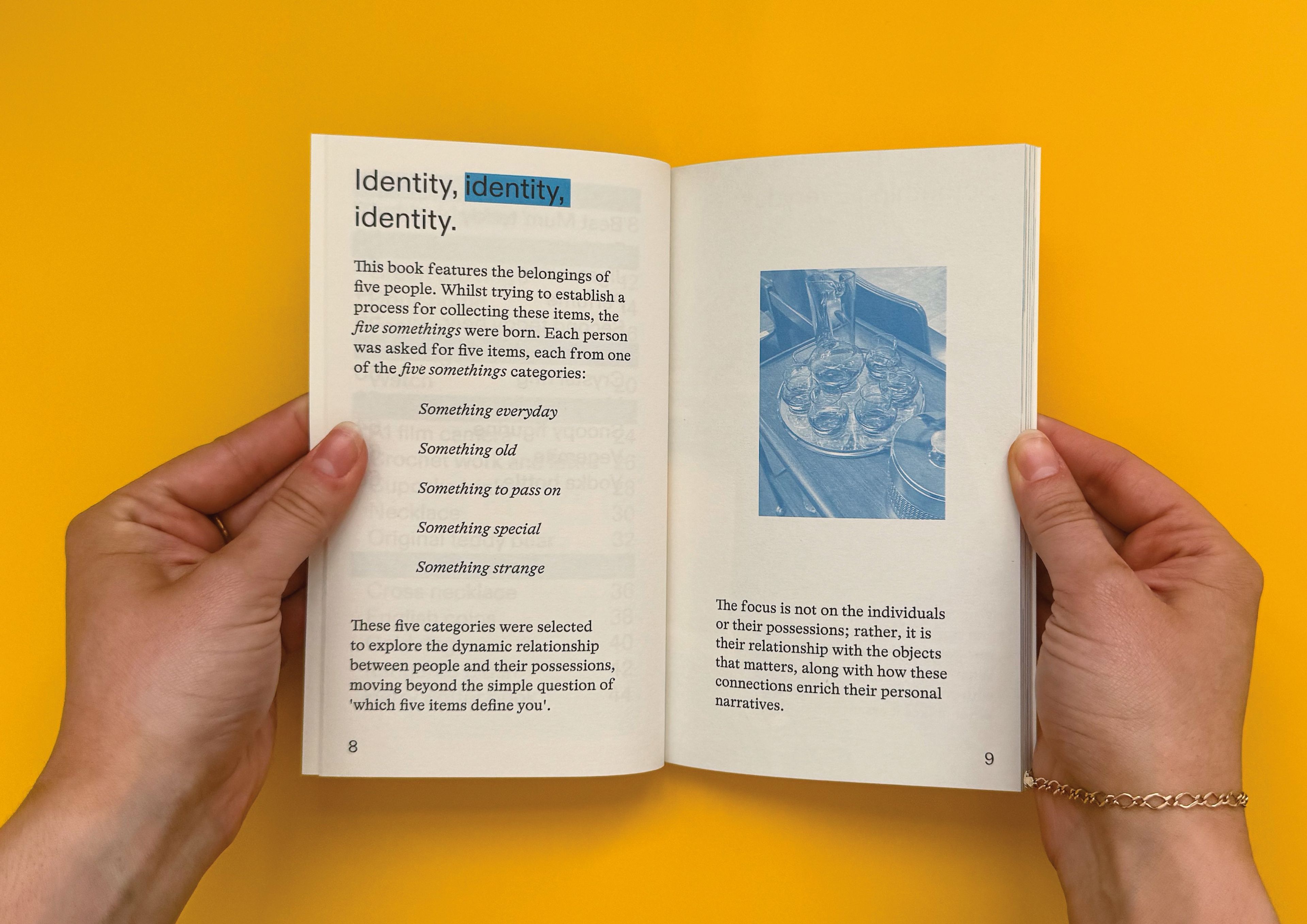 Open book spread with bold text reading 'Identity, identity, identity.' The left page introduces five categories – everyday, old, to pass on, special, and strange – intended to explore personal identity through possessions. The right page includes a blue-tinted photograph of objects arranged on a tray.