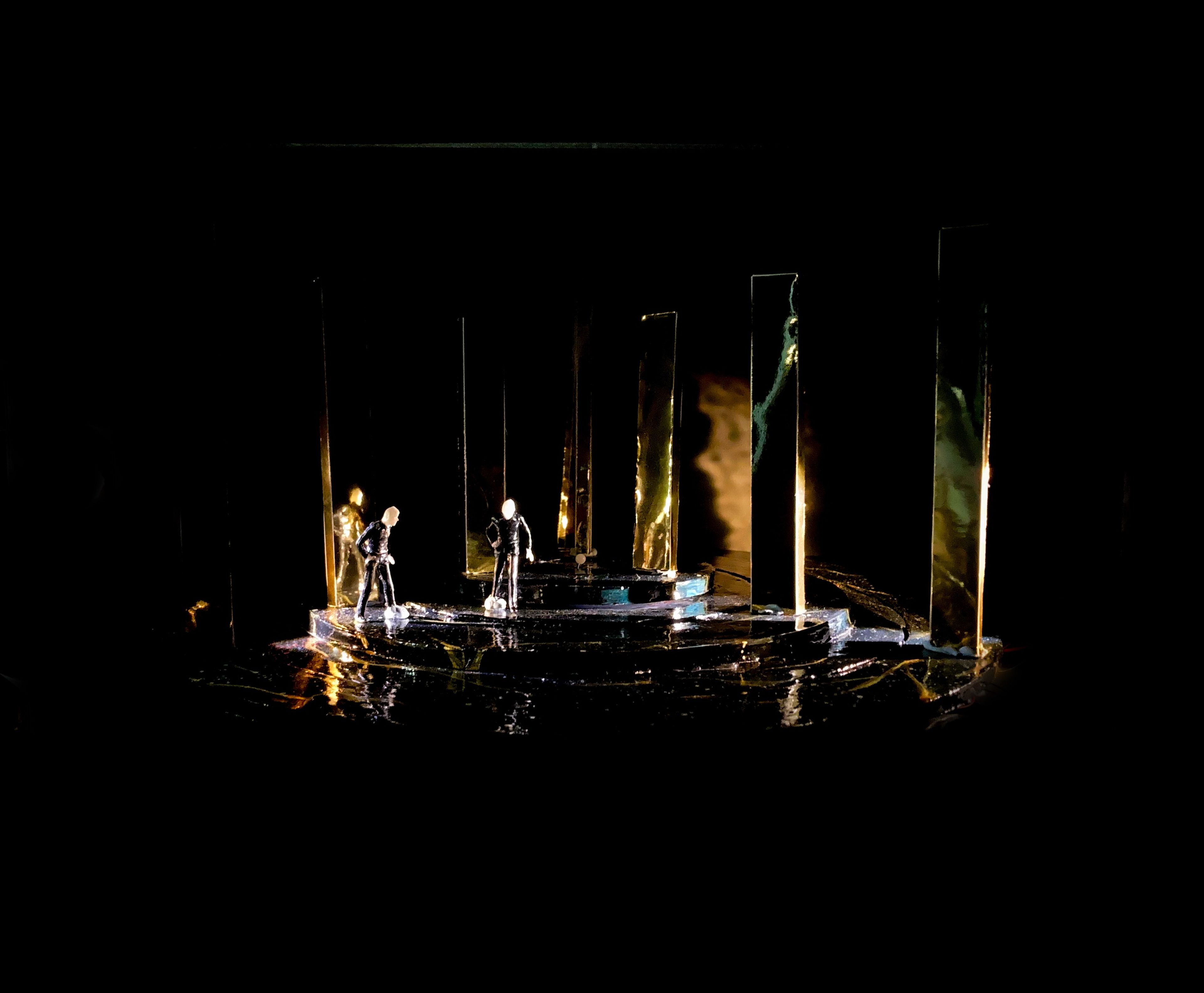 Set model for Act 3, Scene 6, featuring golden vertical panels and figures on a reflective dark stage.