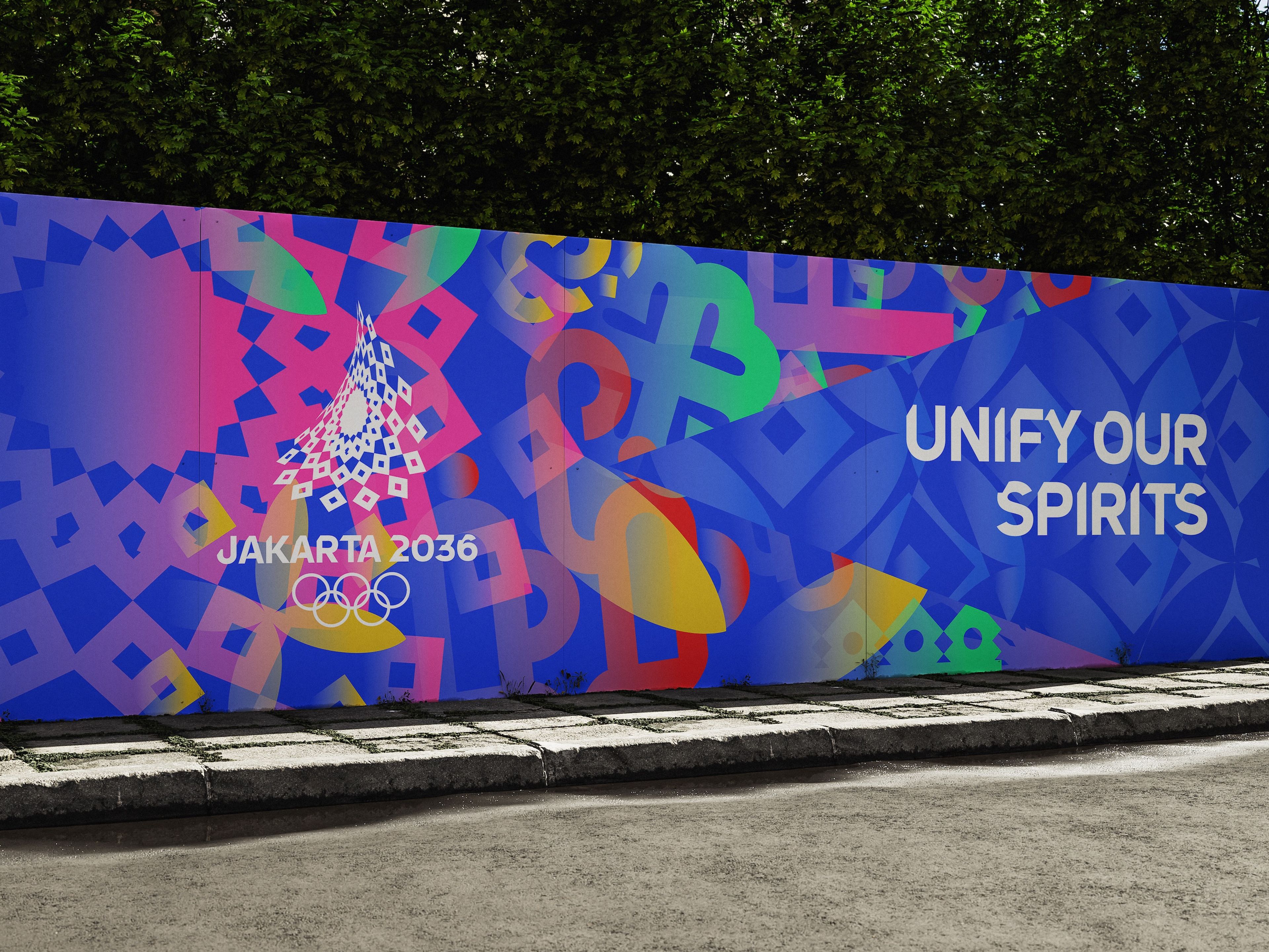 Jakarta 2036 Olympics promotional wall mural featuring vibrant geometric patterns in blue, pink, and yellow. The design includes a stylised white crystal-like logo and the Olympic rings, with text reading 'UNIFY OUR SPIRITS' against a deep blue background. 