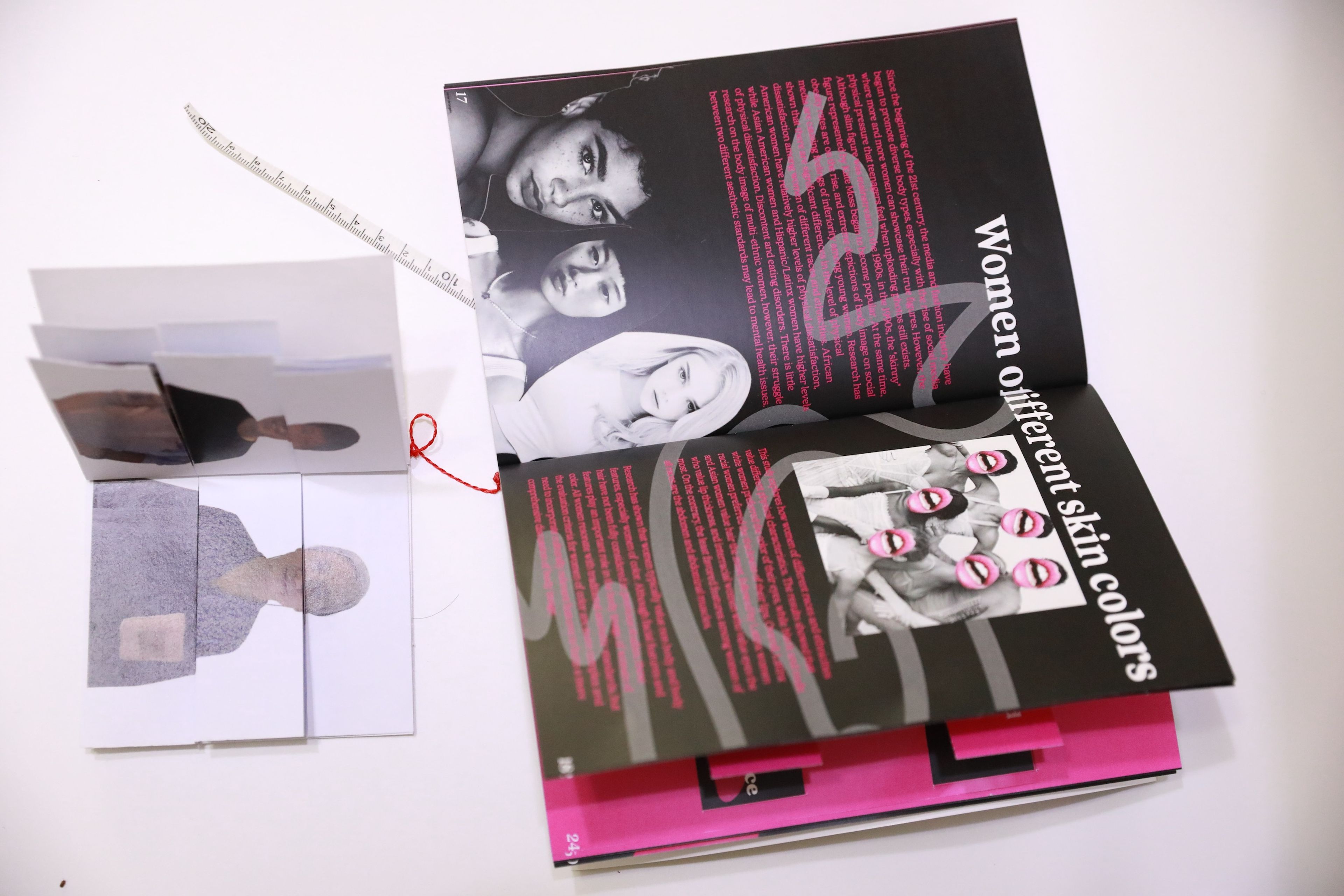 Open spread of a mixed media art book discussing 'Women of Different Skin Colours' in bold white text on black pages with pink accents. The left side features layered portrait cutouts, and the right side showcases diverse faces with stylised pink lines and overlaid lips, surrounded by descriptive text.