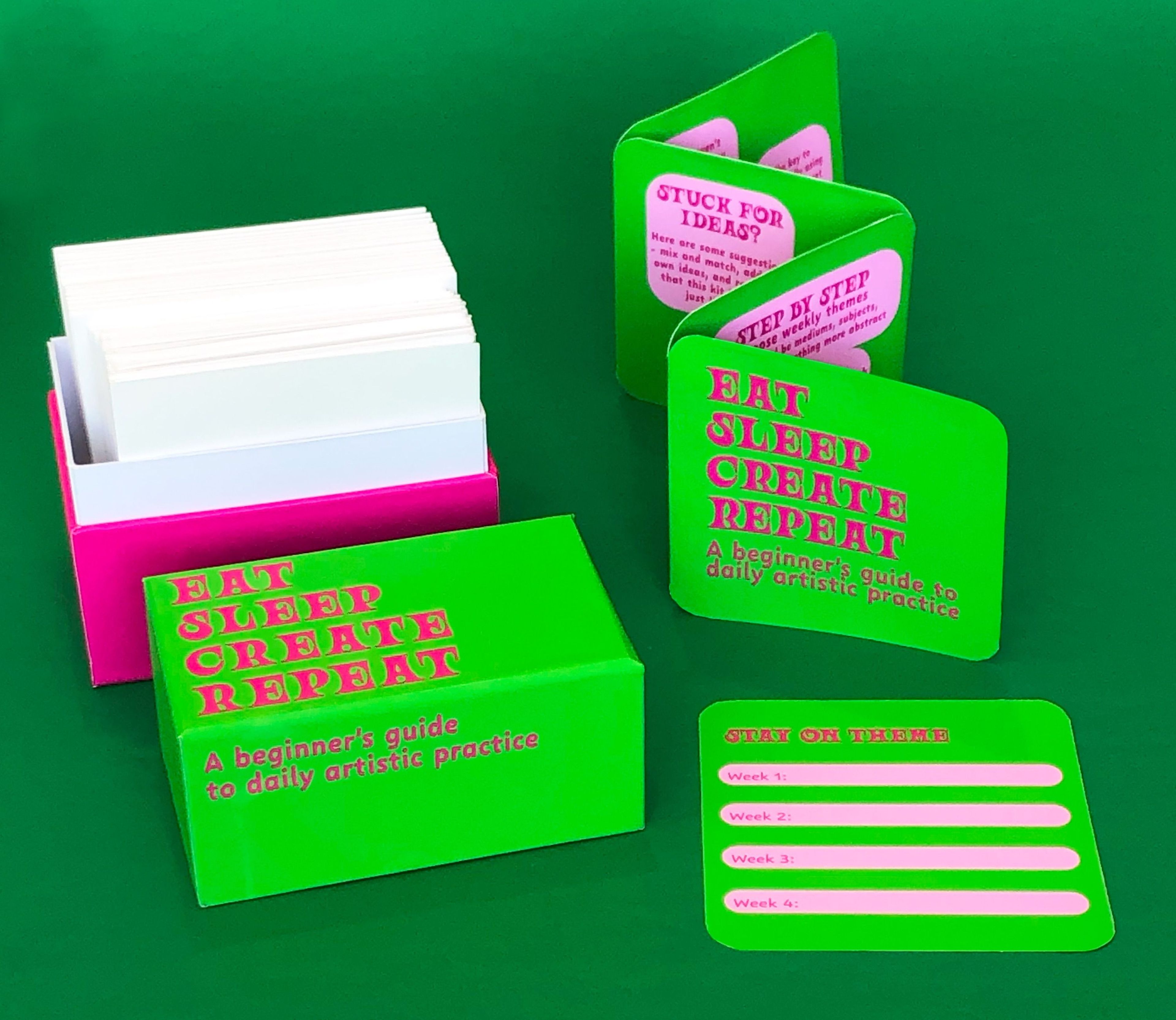 Neon green and pink box set titled "Eat Sleep Create Repeat," with prompt cards and instructional pamphlets. Set on a green background for a bold, playful look.