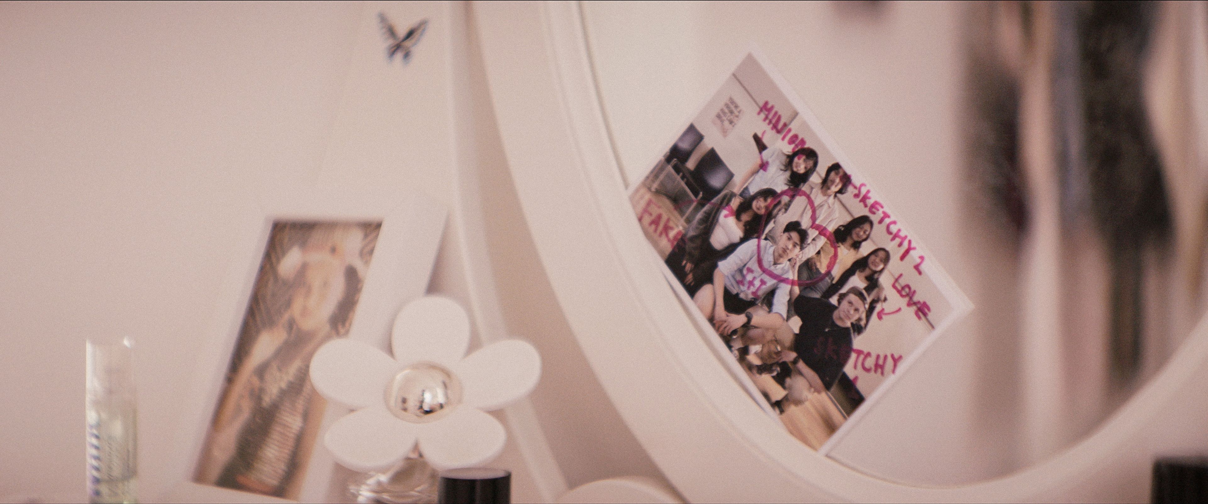 A white vanity mirror prominently features a photo with handwritten annotations