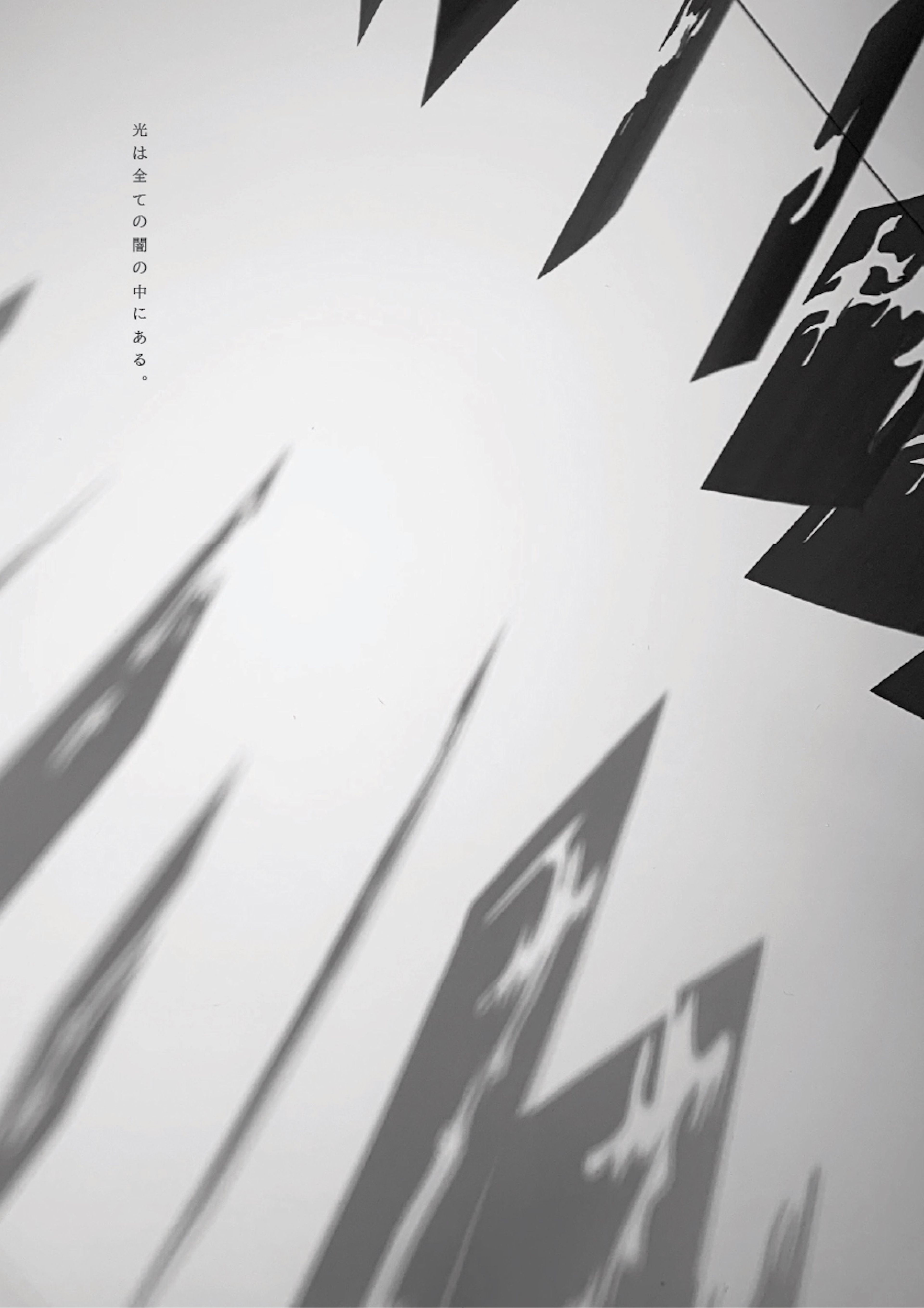 Monochromatic image of abstract shadows cast by pointed, angular shapes against a white wall. Japanese text appears on the left, adding a minimalistic and contemplative atmosphere.