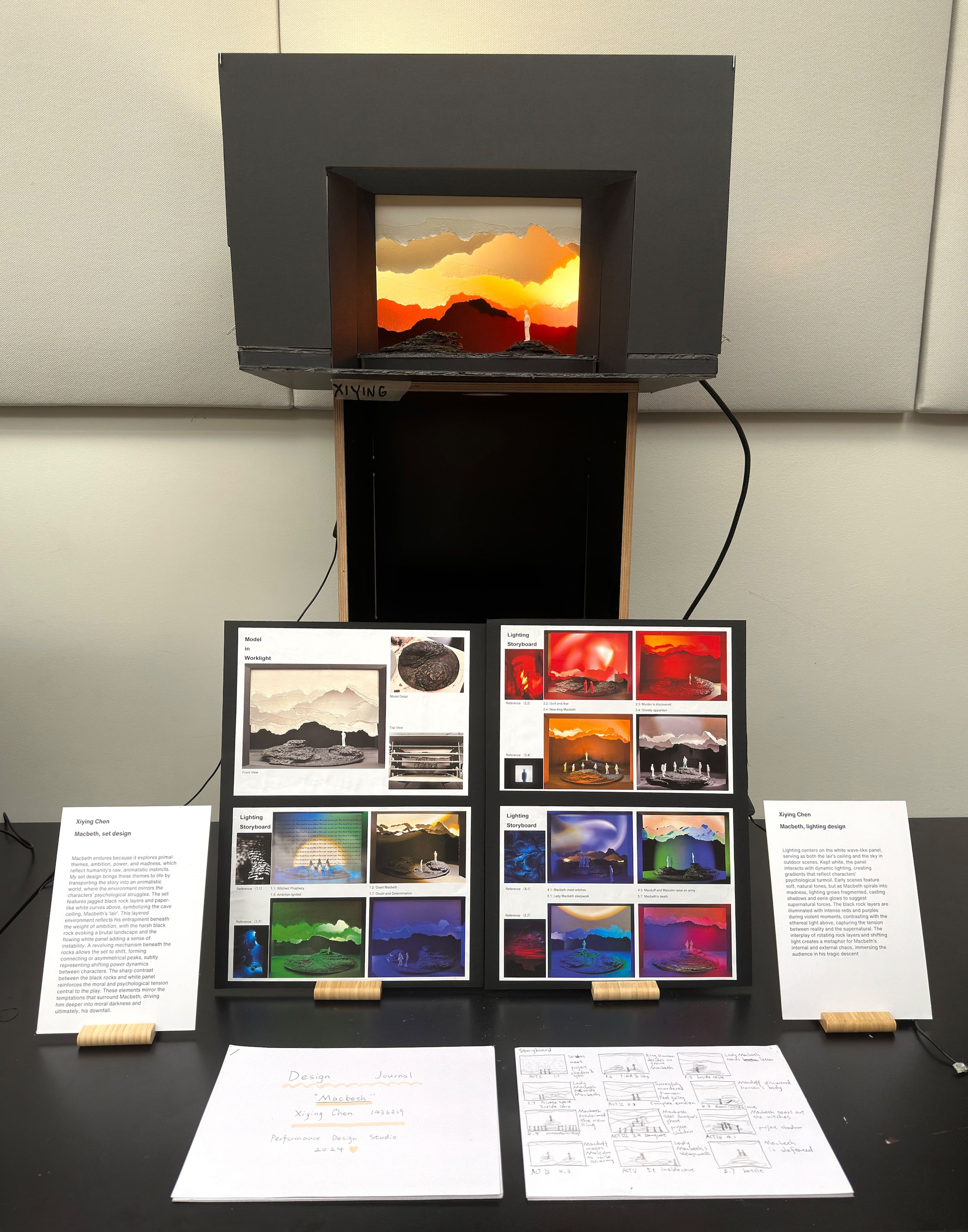 Angled view of exhibition display featuring set model and concept boards showcasing lighting and design choices for a theatrical production.